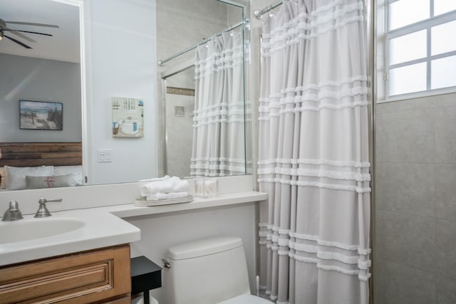 bathroom with vanity, ceiling fan, toilet, and curtained shower