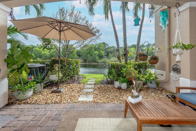 view of patio with a water view and central AC unit