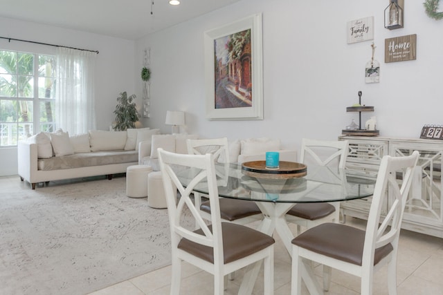 dining space with light tile patterned floors and a healthy amount of sunlight