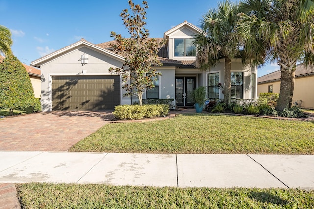 view of front of house featuring a front lawn, a garage, and french doors