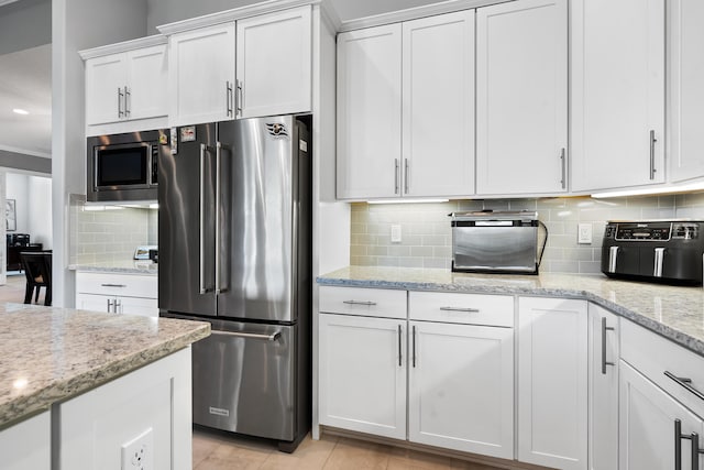 kitchen featuring appliances with stainless steel finishes, backsplash, and white cabinetry