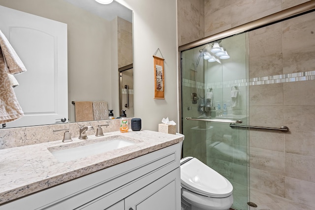 bathroom with vanity, toilet, and an enclosed shower