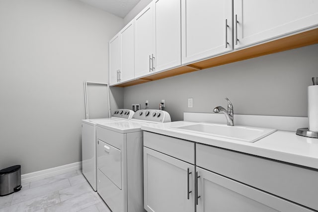 clothes washing area featuring cabinet space, baseboards, independent washer and dryer, marble finish floor, and a sink