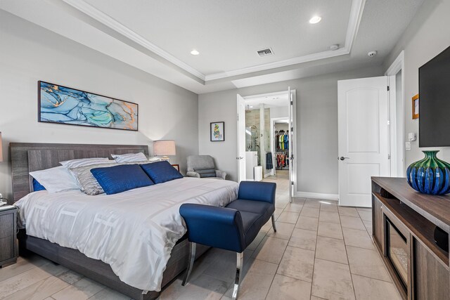 tiled bedroom featuring ornamental molding, a textured ceiling, and a tray ceiling