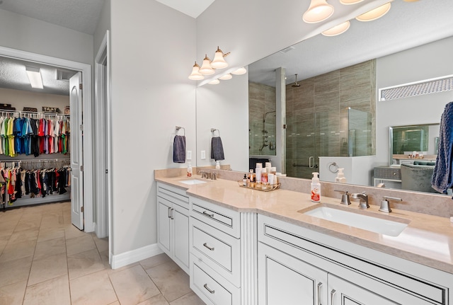 bathroom featuring tile patterned flooring, vanity, a shower with shower door, and a textured ceiling