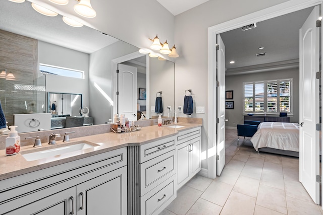 bathroom featuring a tile shower, vanity, and tile patterned floors