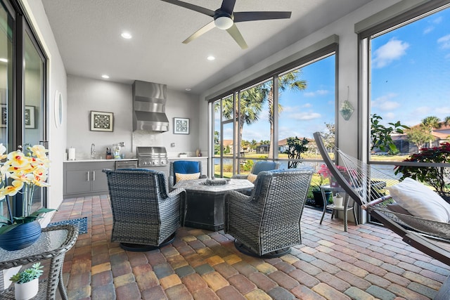 sunroom with ceiling fan and sink