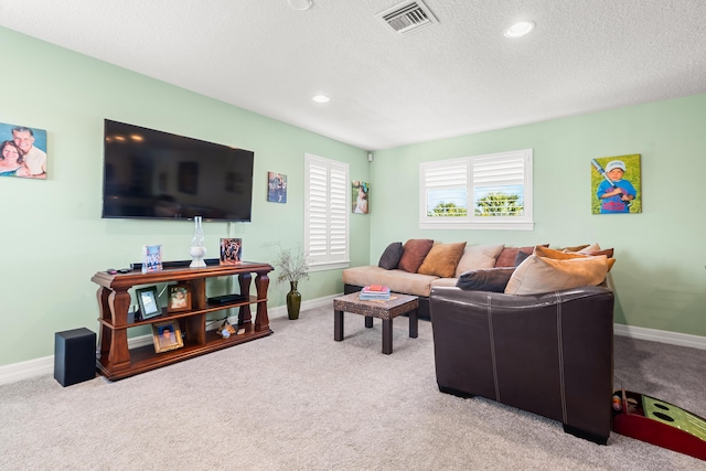 carpeted living room featuring a textured ceiling