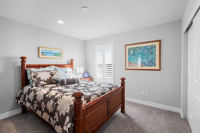 carpeted bedroom featuring a textured ceiling and a closet