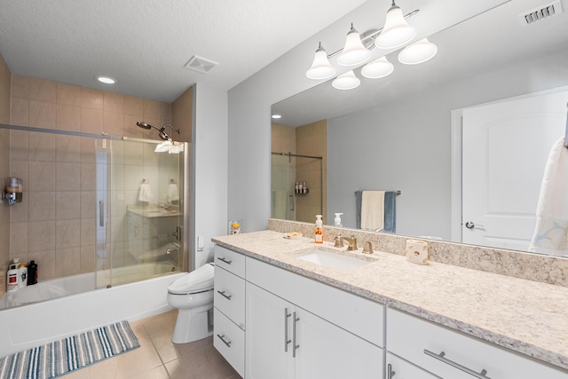 full bathroom featuring combined bath / shower with glass door, vanity, a textured ceiling, tile patterned flooring, and toilet