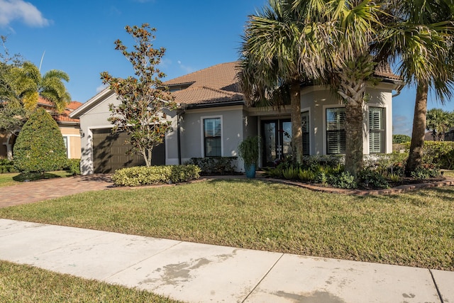 mediterranean / spanish house with a front yard and a garage