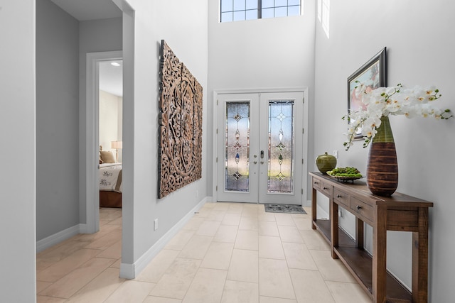 entryway featuring plenty of natural light, a towering ceiling, and french doors