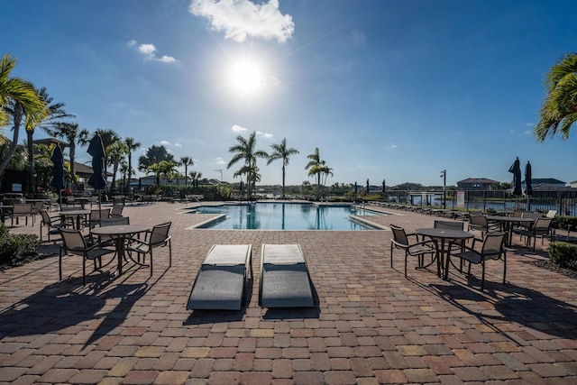 pool with a patio area and fence