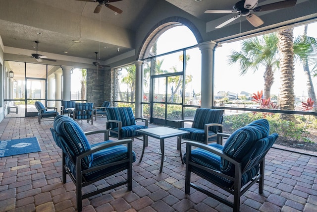 sunroom / solarium featuring ornate columns and ceiling fan