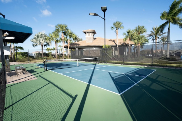 view of tennis court with basketball hoop