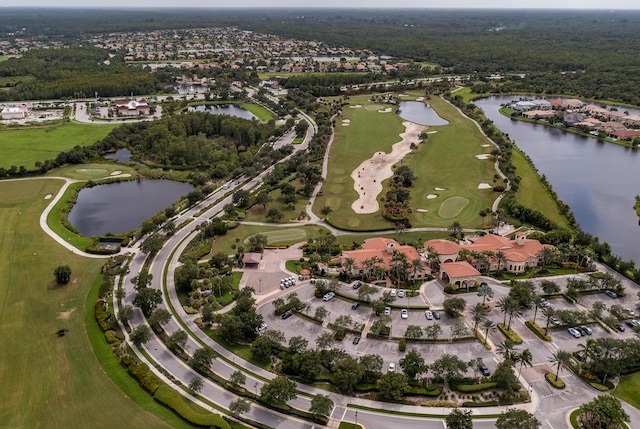 birds eye view of property with golf course view and a water view