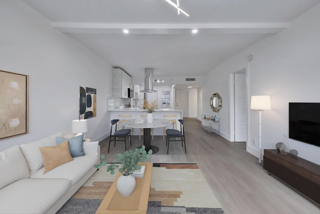 living area with beamed ceiling, recessed lighting, light wood-style flooring, and baseboards