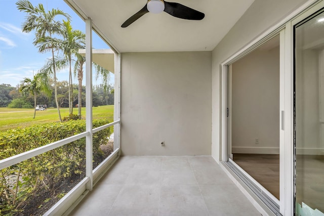 unfurnished sunroom featuring a ceiling fan and a healthy amount of sunlight