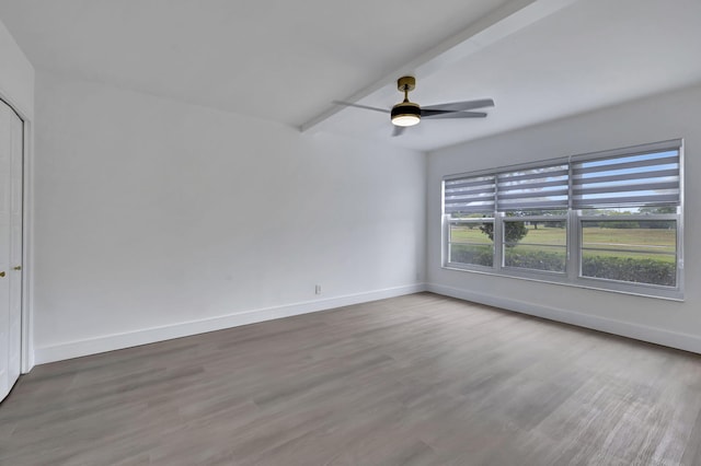 unfurnished room with ceiling fan, hardwood / wood-style flooring, and beamed ceiling