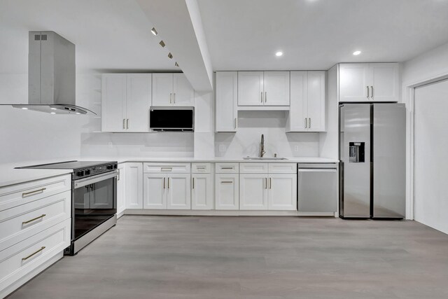 kitchen featuring white cabinetry, sink, light hardwood / wood-style flooring, and appliances with stainless steel finishes