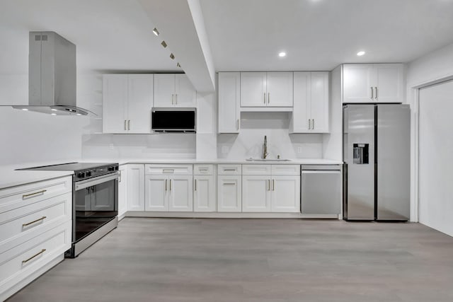 kitchen with island exhaust hood, stainless steel appliances, light countertops, white cabinets, and a sink