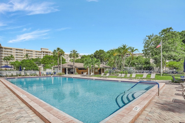 pool with a patio area and fence