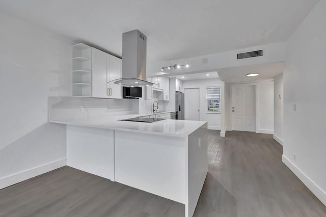 kitchen featuring open shelves, visible vents, white cabinets, a sink, and island range hood