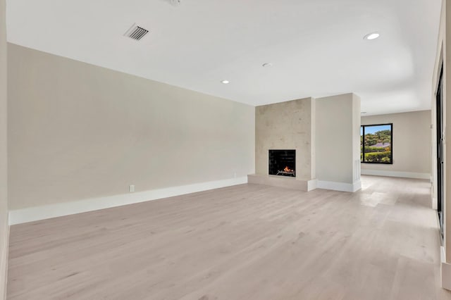 unfurnished living room with light wood-type flooring and a fireplace