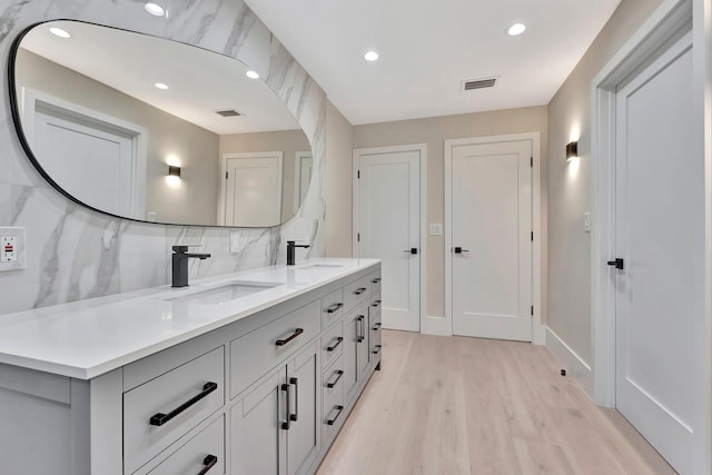 bathroom with vanity, backsplash, and hardwood / wood-style flooring