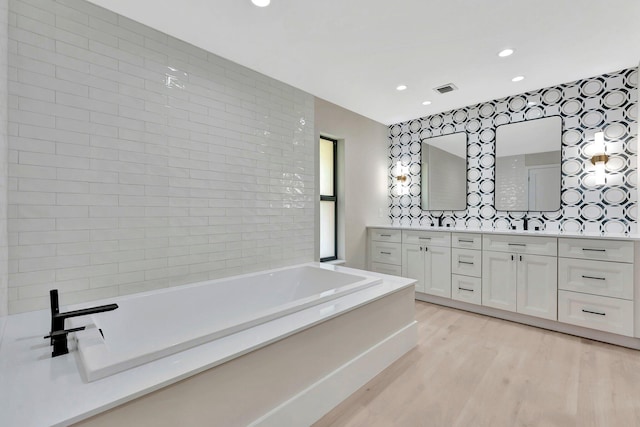 bathroom with vanity, a tub, and hardwood / wood-style flooring