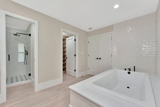 bathroom featuring hardwood / wood-style floors and independent shower and bath