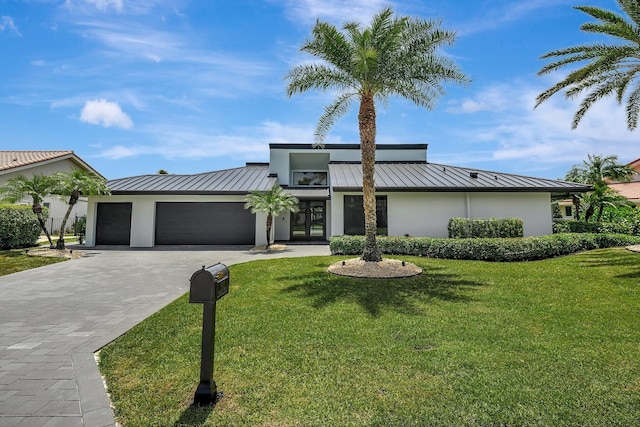 view of front of property with a garage, a front yard, and french doors