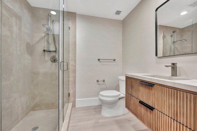 bathroom with toilet, an enclosed shower, and vanity