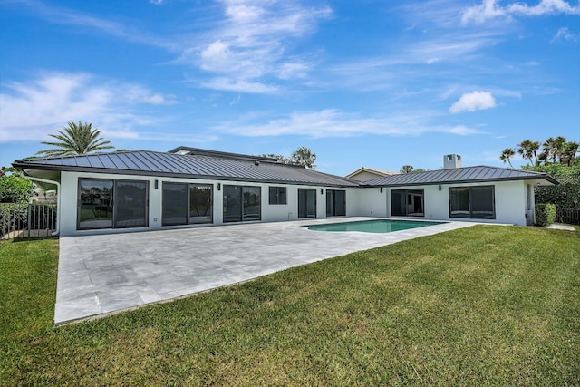 rear view of property with a yard and a patio