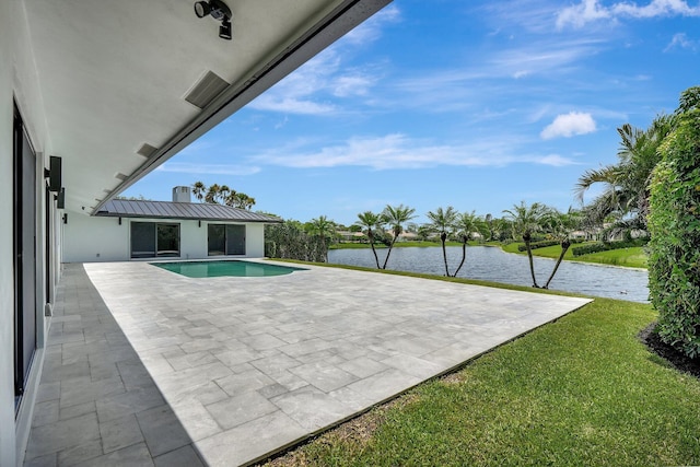 view of pool with a water view, a patio area, and a yard