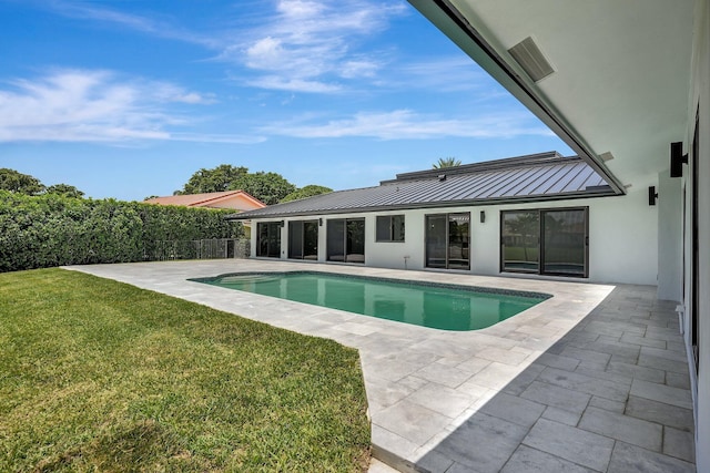 view of pool with a patio area and a yard