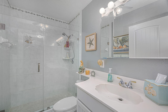 bathroom featuring ceiling fan, toilet, vanity, and walk in shower