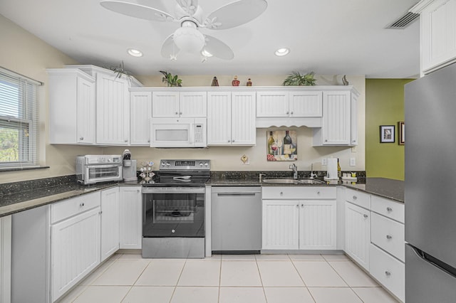 kitchen featuring white cabinets, dark stone counters, sink, and stainless steel appliances