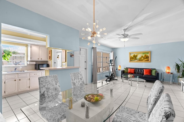 dining room with light tile patterned flooring, ceiling fan with notable chandelier, and sink