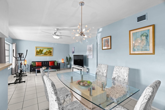 dining space with ceiling fan with notable chandelier and light tile patterned floors