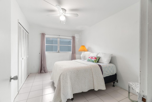 bedroom with light tile patterned floors, a closet, and ceiling fan