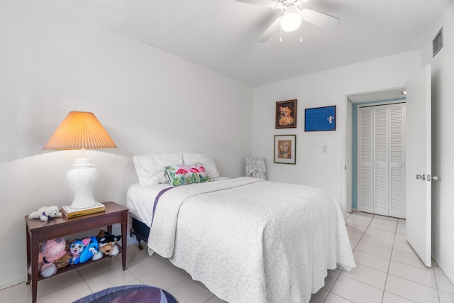 tiled bedroom featuring ceiling fan and a closet