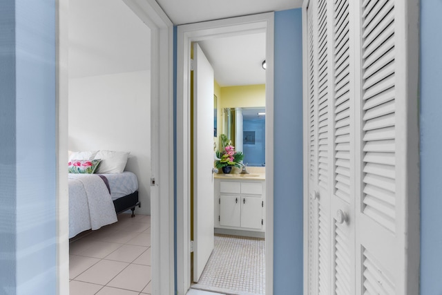 corridor with light tile patterned flooring and sink