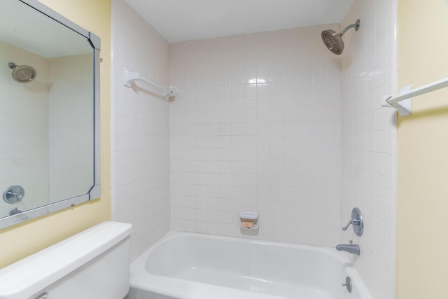 bathroom with tiled shower / bath combo and toilet