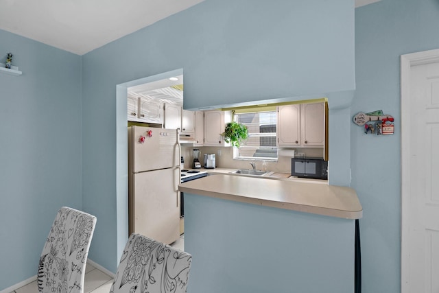 kitchen with stove, ventilation hood, sink, light tile patterned floors, and white refrigerator