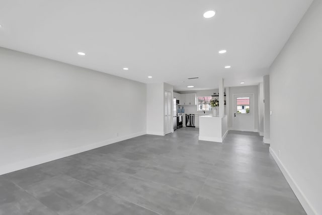 unfurnished living room with concrete flooring