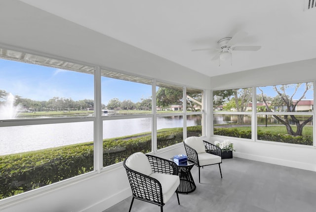 sunroom featuring ceiling fan and a water view