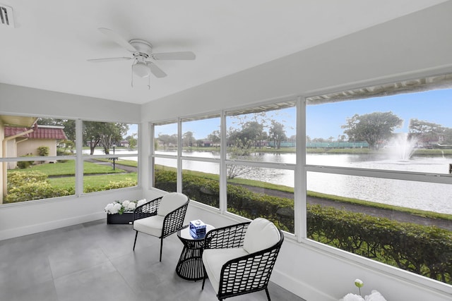 sunroom featuring a water view and ceiling fan