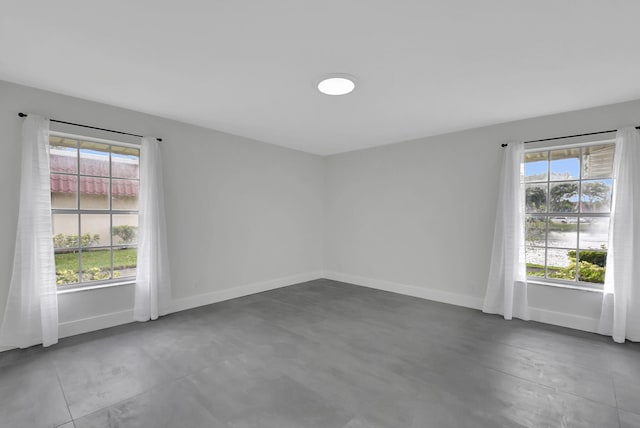 spare room with a wealth of natural light and concrete floors