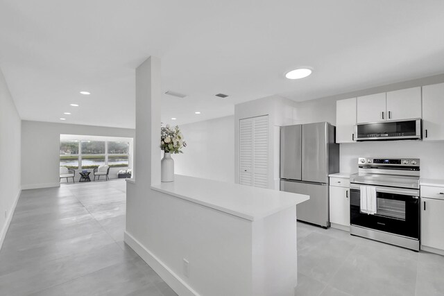 kitchen featuring kitchen peninsula, stainless steel appliances, and white cabinetry